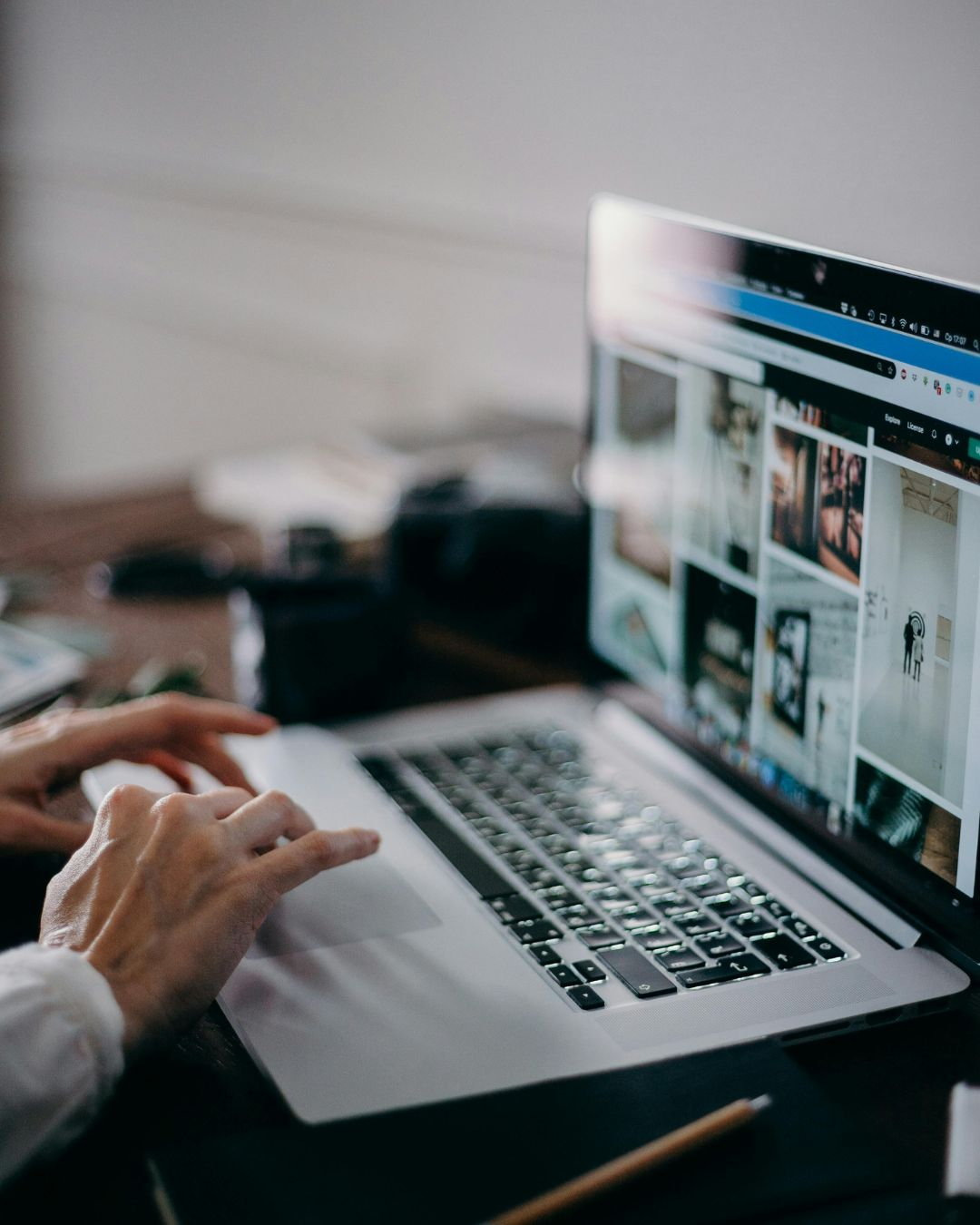 Person working on a laptop, optimizing digital content to ensure your website should work as hard as you do.