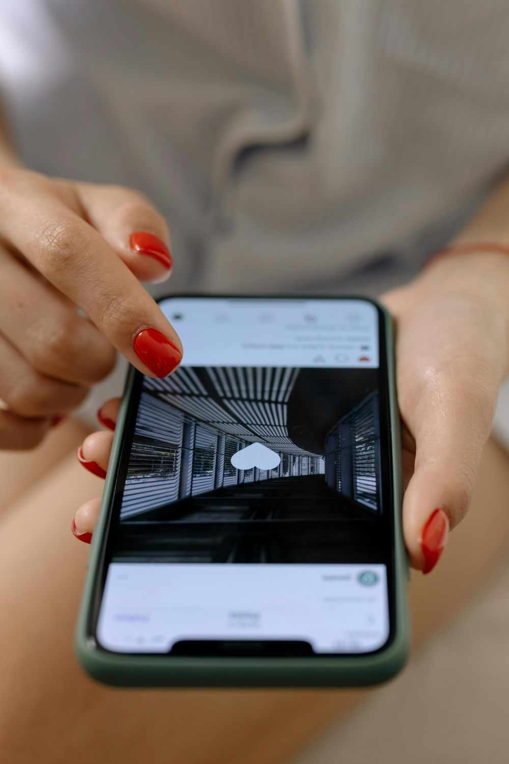 Close-up of a person tapping like on an Instagram post with red manicured nails – modern social media engagement concept