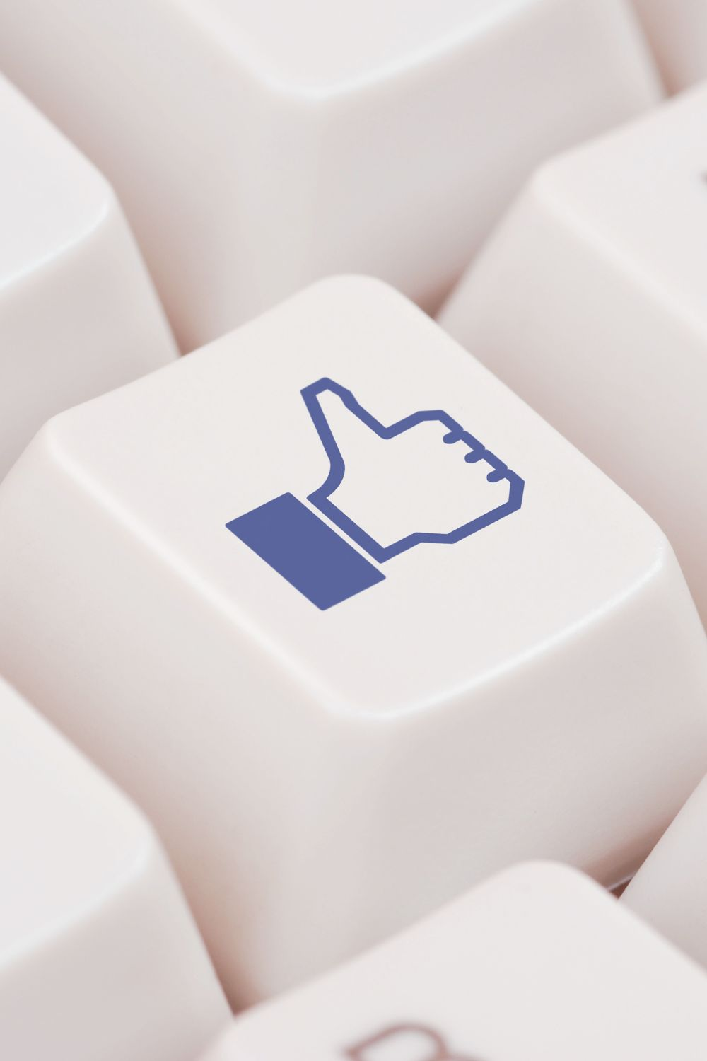 Close-up of a keyboard key with a Facebook thumbs-up icon, symbolizing engagement and the best time to post on Facebook for business success.