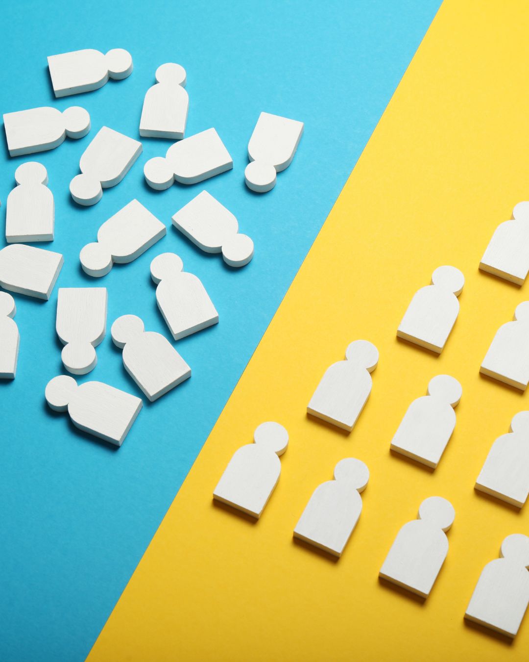 White wooden person-shaped tokens scattered randomly across a blue background on the left, contrasted with neatly aligned tokens on a yellow background on the right, illustrating unfocused audience versus targeted engagement.