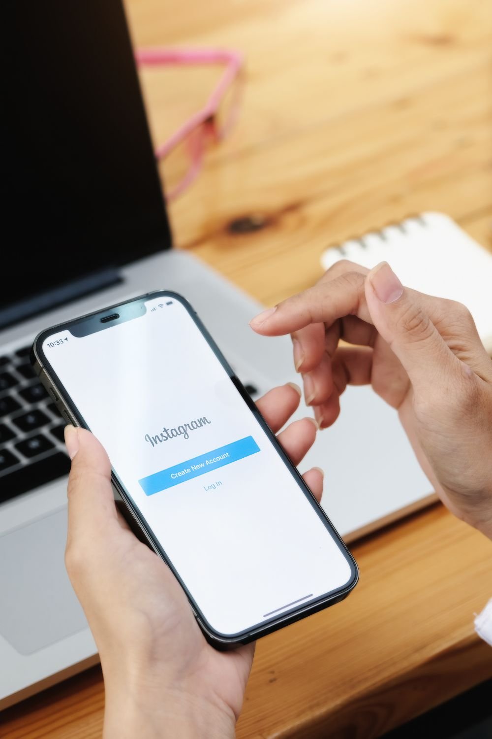 Person holding a smartphone with the Instagram login screen open, ready to create a new account.