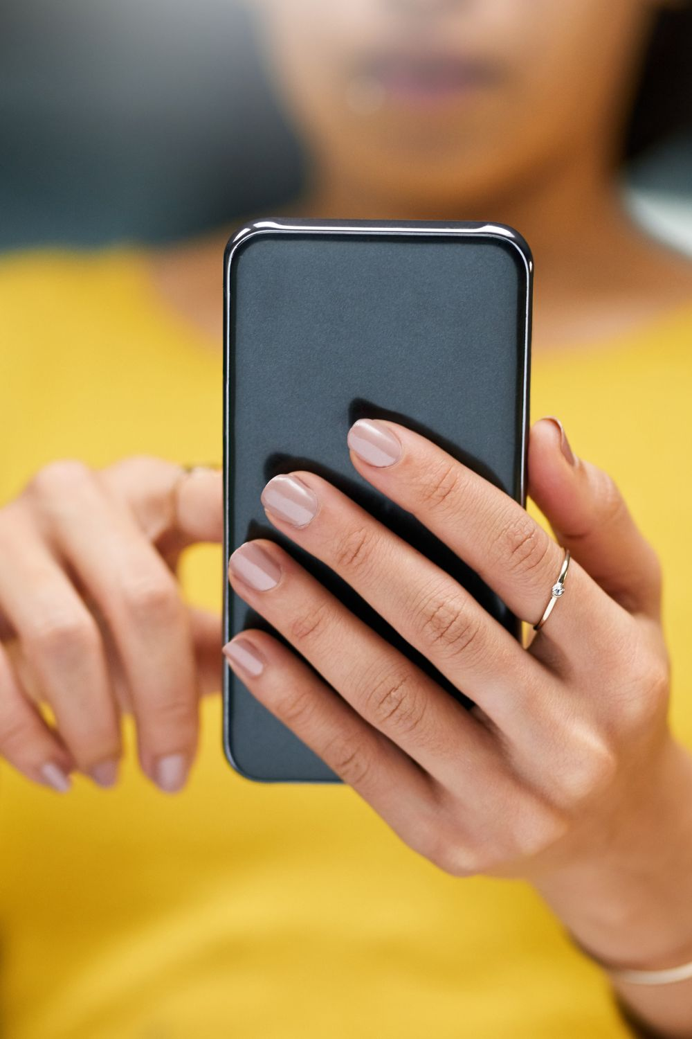 Close-up of a woman using a smartphone, representing mobile social media marketing and engagement.