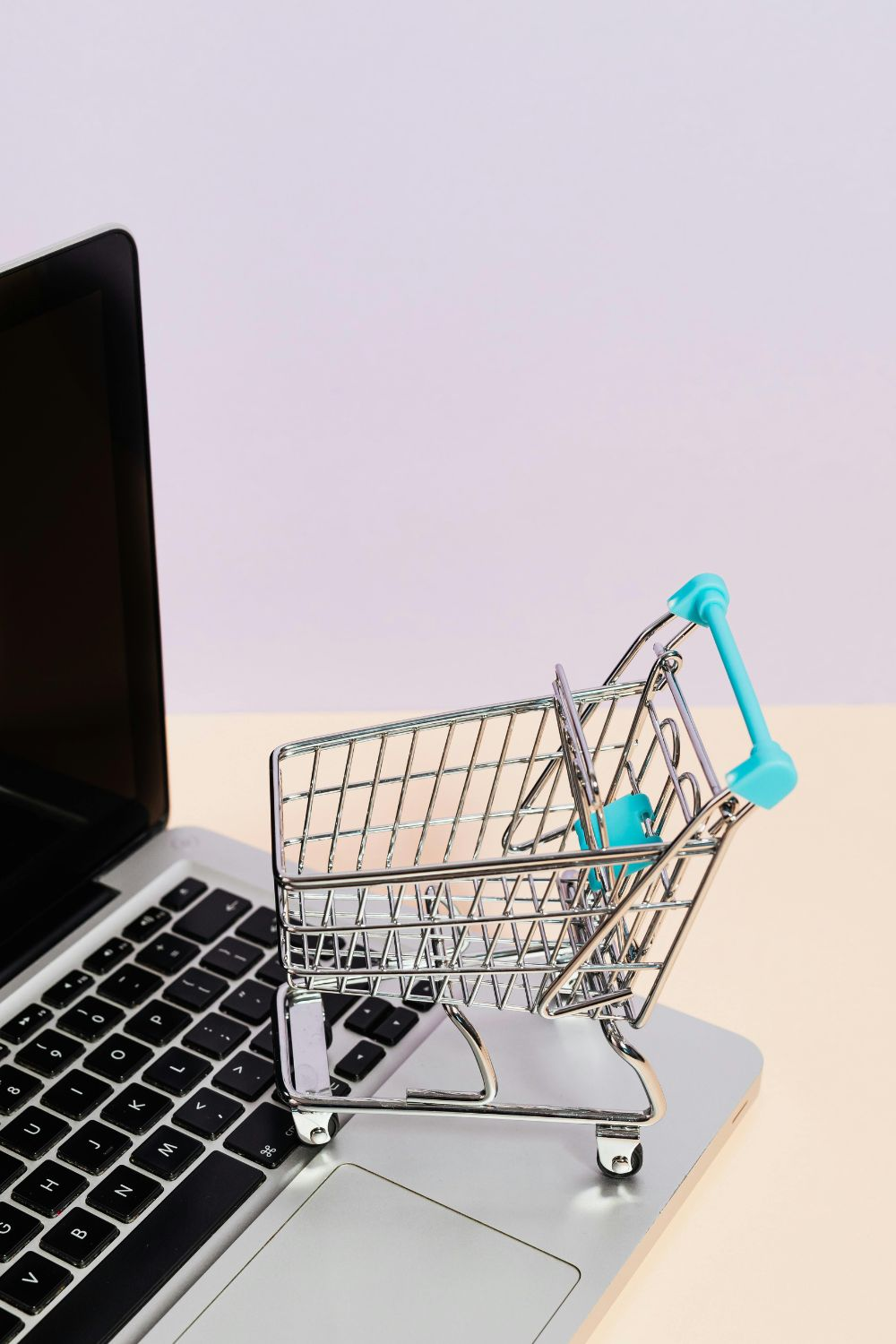 Mini shopping cart on a laptop keyboard symbolizing the social media shopping future and online commerce.