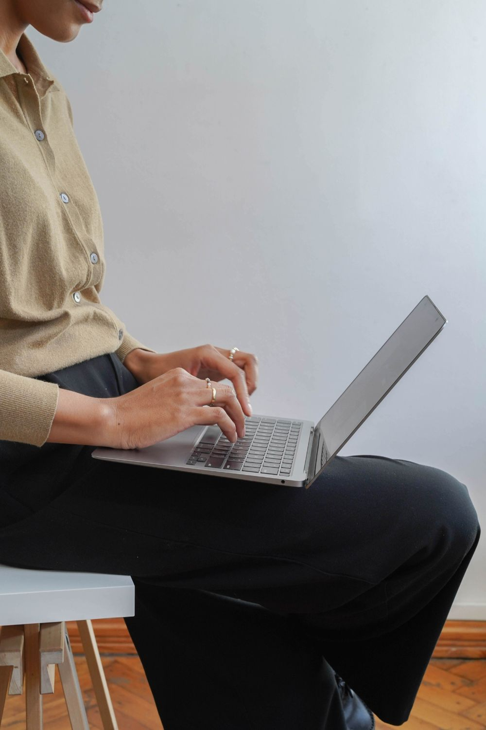 Close-up of a person typing on a laptop while working on social media strategy in business.