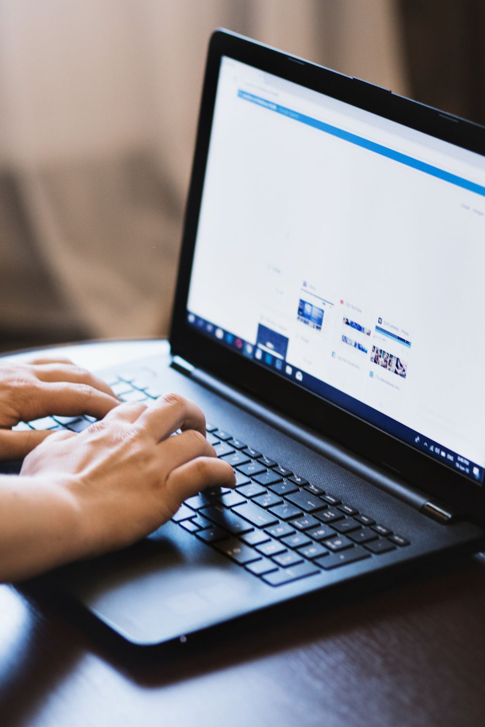 Person typing on a laptop while browsing websites, representing small business website creation and digital marketing strategy.