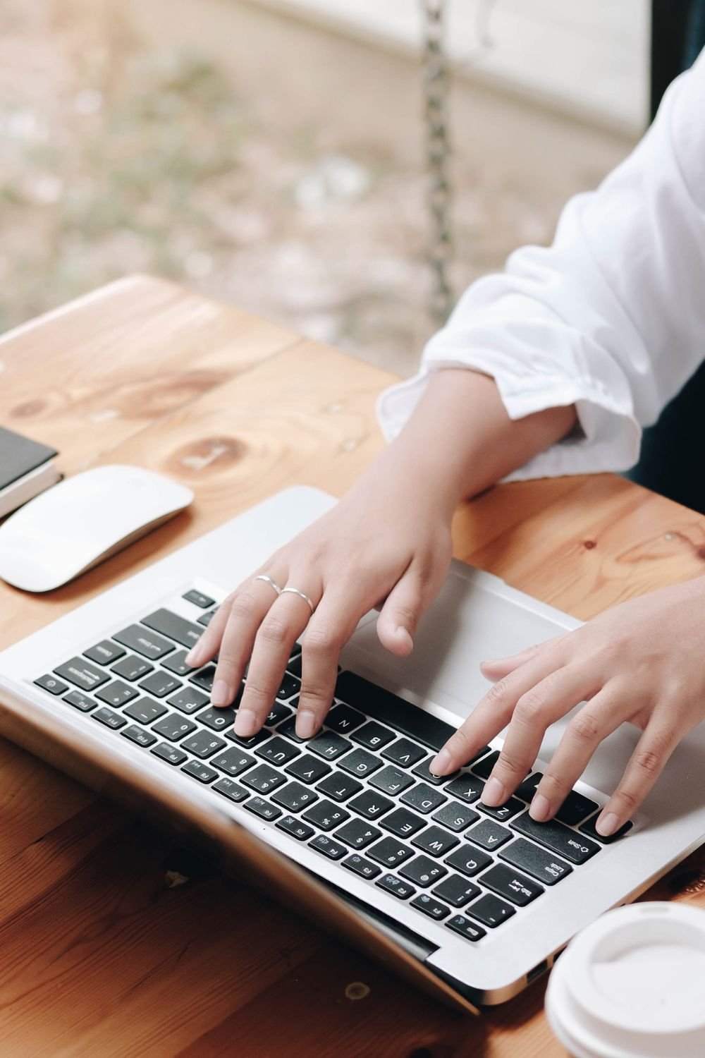 Hands typing on laptop while planning social media campaign length strategies.
