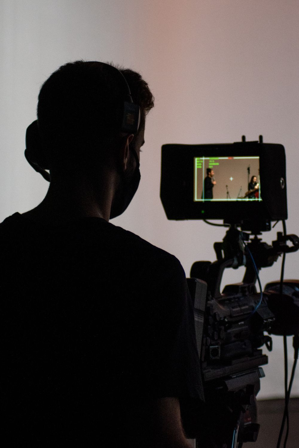 Videographer recording creators on a professional camera during a studio shoot for social media content.